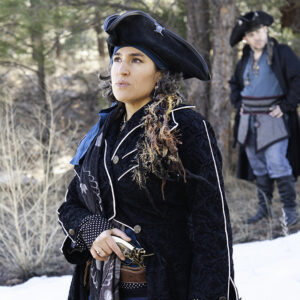 Staci dressed in Steam Punk attire - staring off to the left off screen, stoic.