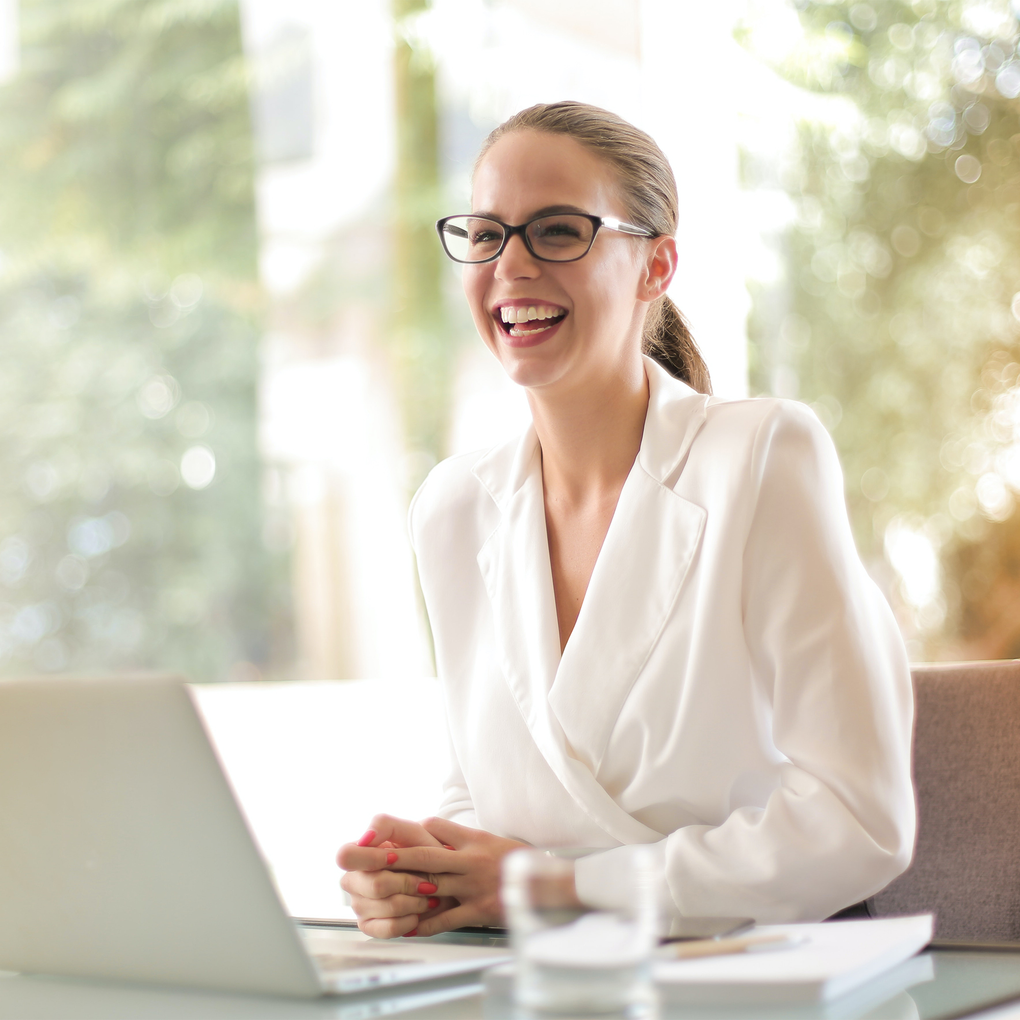 Happy Woman smiling at her computer, business professional